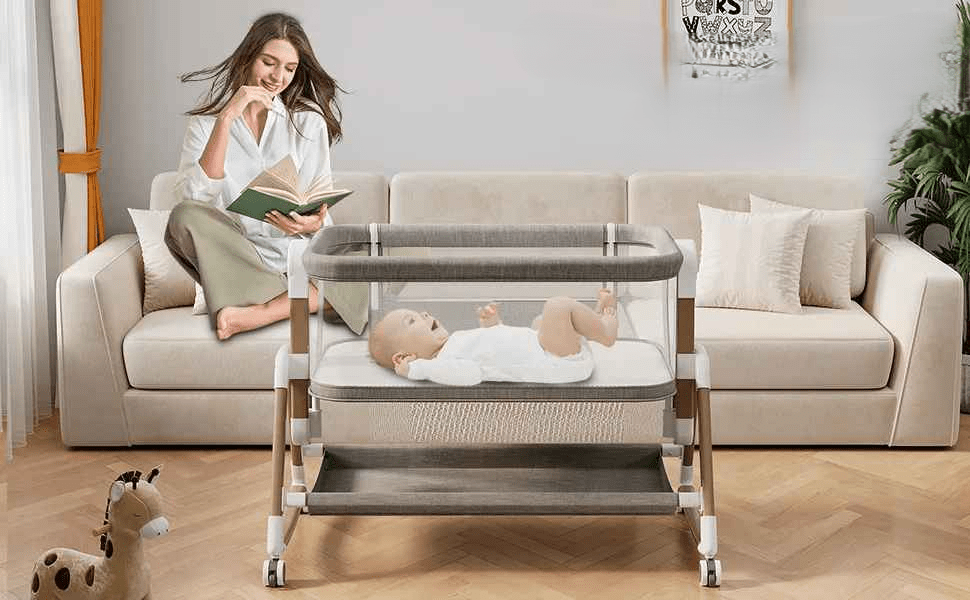 maman assis sur le canape entrain de lire un livre pendant que son bebe est tranquillement allonger dans son cododo a cote