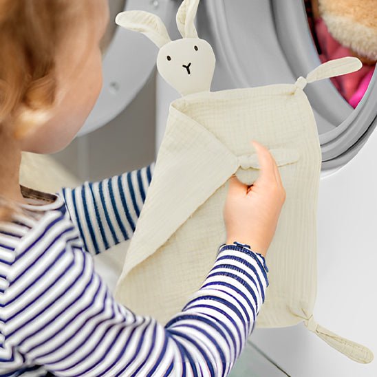 doudou bebe enfants qui tiens le lapin dans ces mains qui va mettre son ami dans la machine a laver