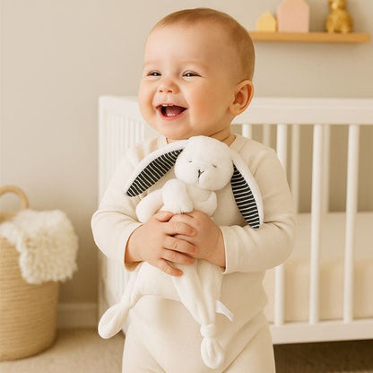 doudou bebe qui est debout dans sa chambre avec son petit lapin dans les mains