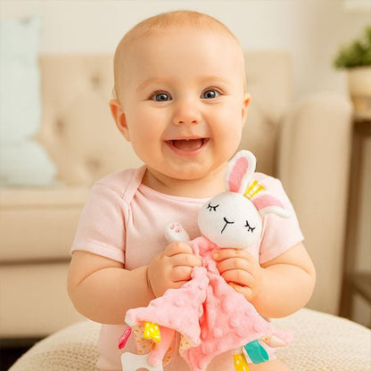 doudou lapin rose avec un bebe qui sourit tenant son doudou dans les mains