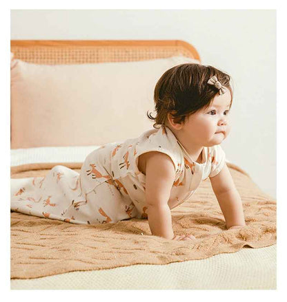 petite fille a quatre pattes sur le lit de ces parents avec sa gigoteuse renard