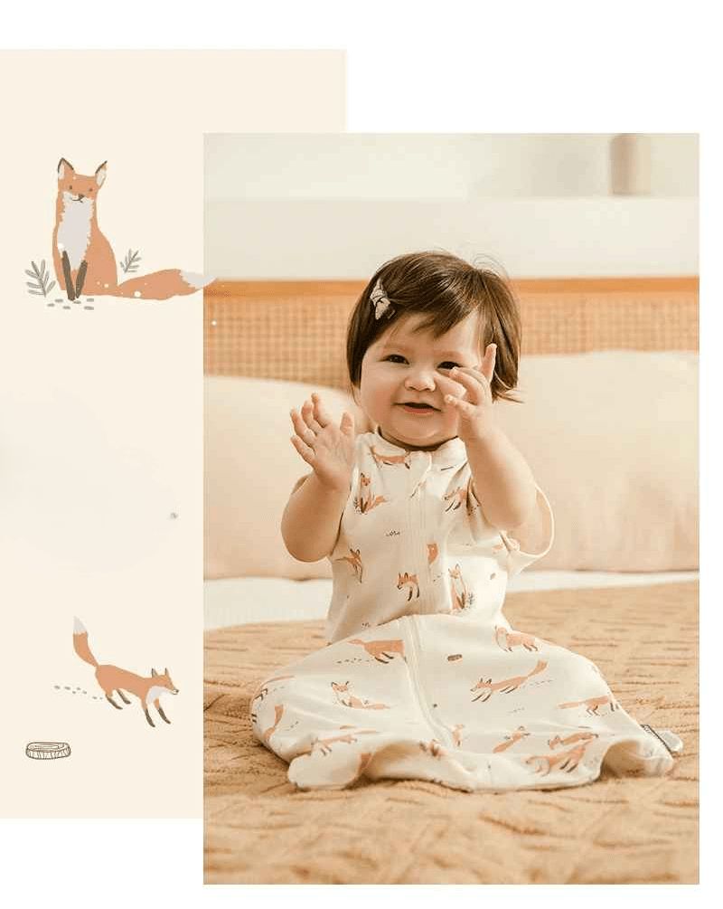 petite fille assis sur un grand lit avec sa gigoteuse avec des renard image de renard sur le cote