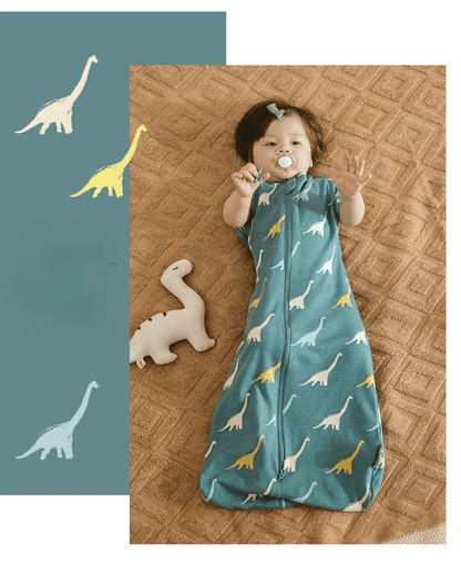 image avec un enfant allonger sur une couverture tendant les bras vers le haut dans sa gigoteuse dinosaure