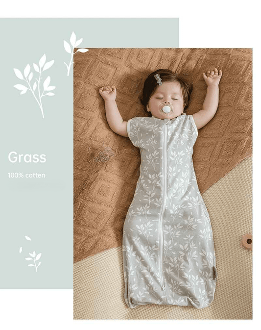 bebe qui dort les bras en l'air dans sa gigoteuse été avec des petites herbes dans les ton vert