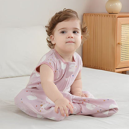 petite fille assise avec sa gigoteuse rose avec des cygnes