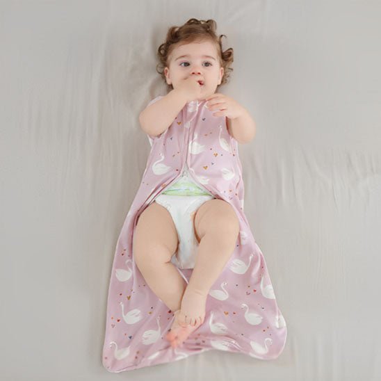 petite fille allonger sur le lit avec la gigoteuse ouverte par les pied pour faciliter les changes sans enlever complètement la gigoteuse