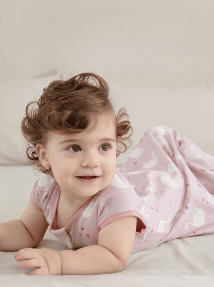 petite fille allonger sur le ventre avec sa gigoteuse sur elle