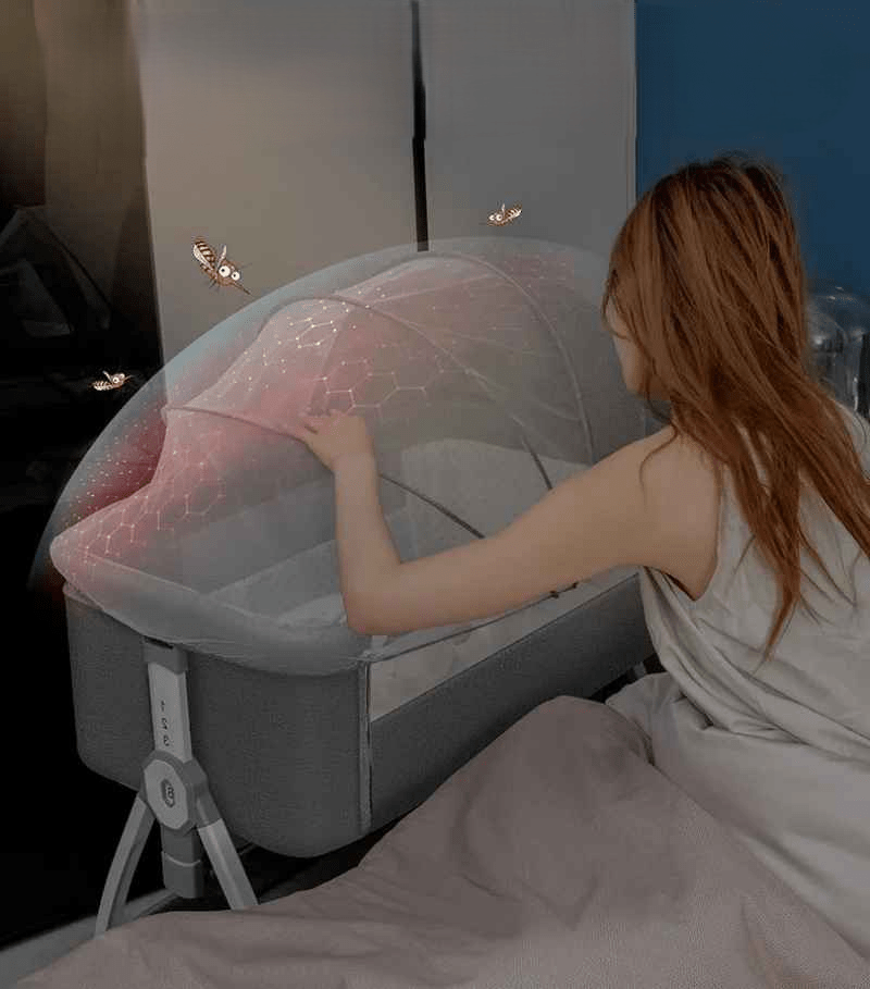 lit cododo maman qui surveille son bebe dans la nuit qui es protéger avec une moustiquaire