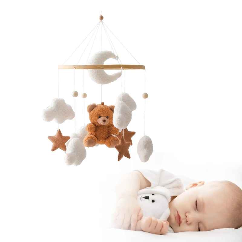 mobil pour lit bebe avec un nourrisson qui dort avec le nounours suspendu au dessus de sa tête