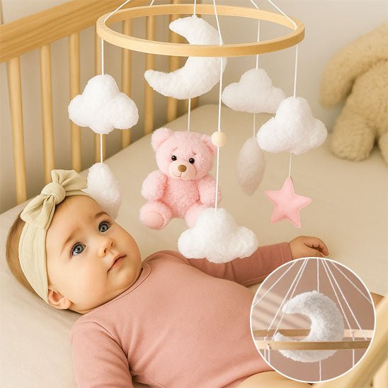 mobil pour lit bebe suspendu au dessus du berceau avec une petite fille qui regarde attentivement les petits objets bouger