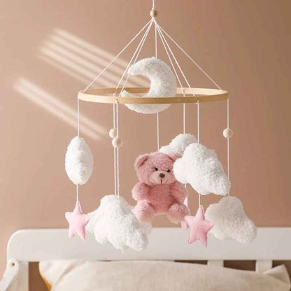 mobil pour lit bebe suspendu au dessus du lit a barreau avec le nounours rose et blanc