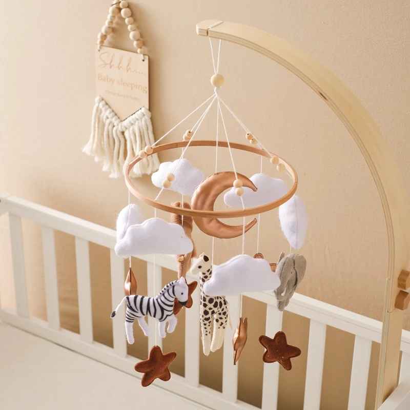 mobile bébé en bois avec des animaux et des forme dans le ciel dans la chambre bebe