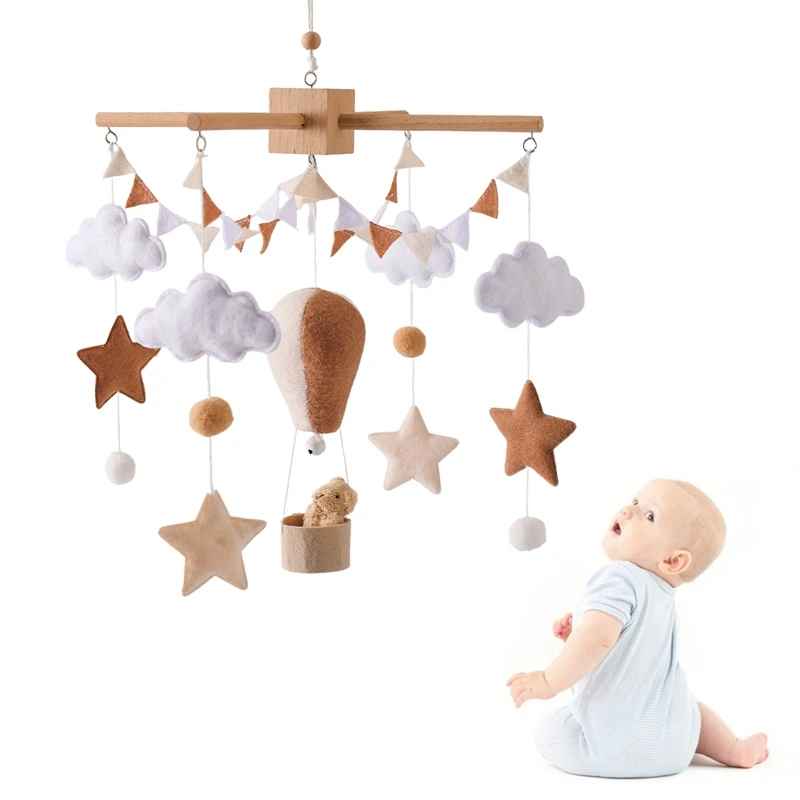 mobile bebe fond blanc avec un petit garçon assis qui regarde les figurines bouger suspendu