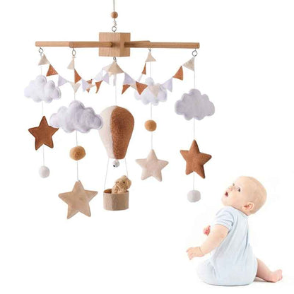 mobile bebe fond blanc avec un petit garçon assis qui regarde les figurines bouger suspendu