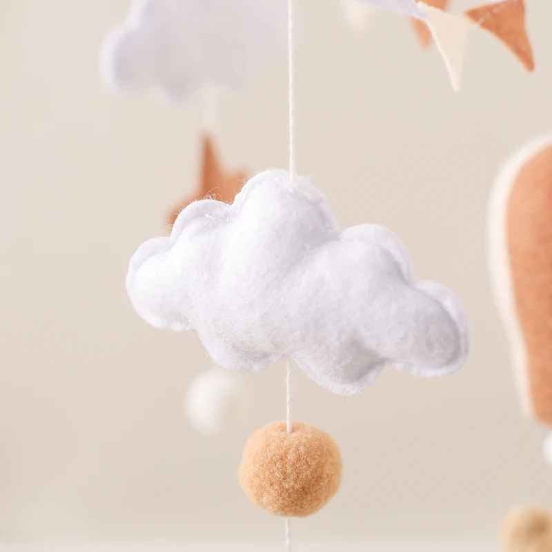 mobile bebe montrant le nuage avec la petite boule suspendu au bois