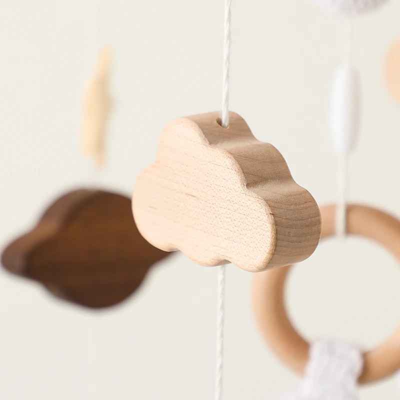mobile bebe qui montre le nuage suspendu en bois naturelle sur une corde