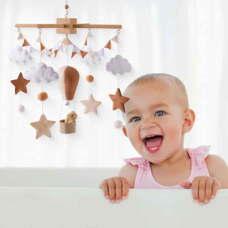 mobile bebe suspendu dans la chambre avec la petite fille debout dans son lit souriante