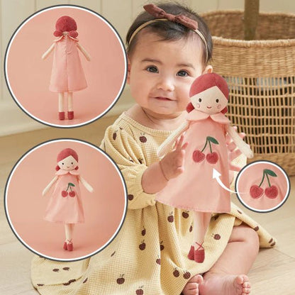 petite fille assise qui tend son doudou devant elle pour montrer sa poupée
