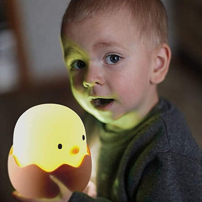 veilleuse bebe avec un gros plan du poussin et petit garçon qui tiens la petite lampe dans les mains allumer 