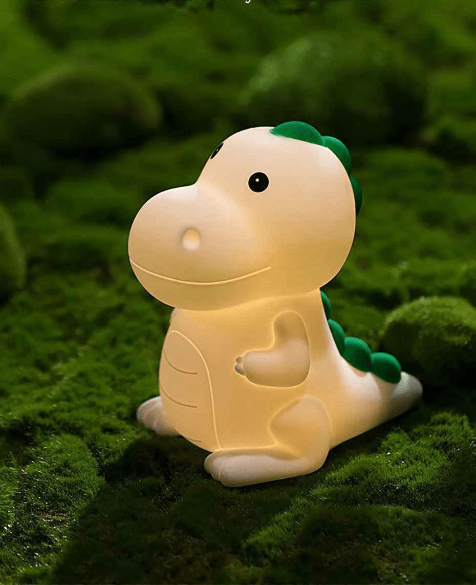 veilleuse bebe dino poser sur de la mousse verte