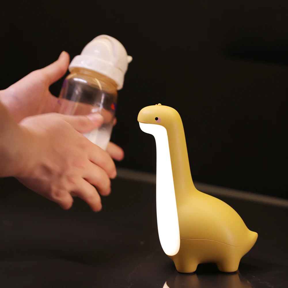 veilleuse bebe dinosaure jaune main qui remu le biberon