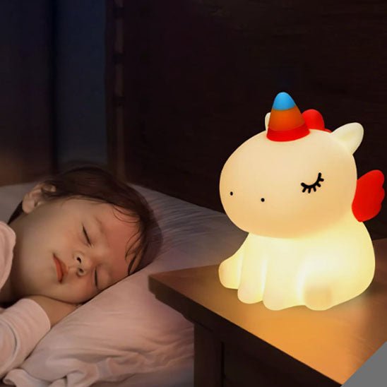 veilleuse bebe enfant qui dort avec sa licorne allumer sur la table de chevet