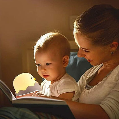 veilleuse bebe enfants qui regarde un livre avec sa maman avec une lumiere tamiser avant de dormir