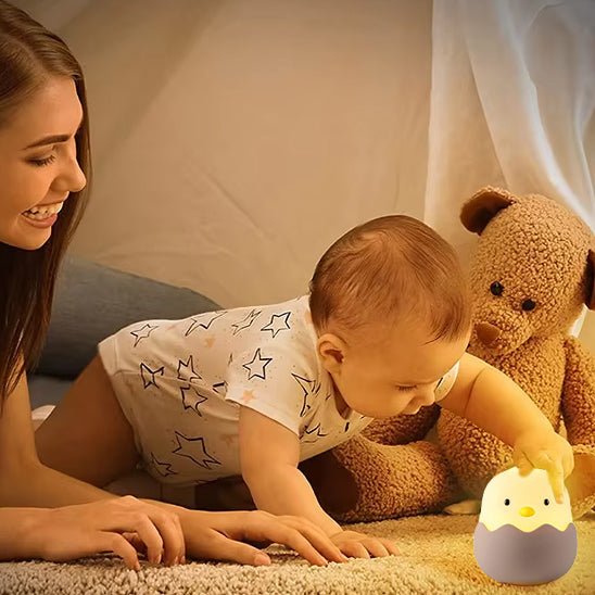 veilleuse bebe qui touche le petit poussin avec sa maman dans sa chambre