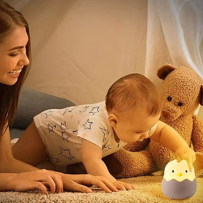 veilleuse bebe qui touche le petit poussin avec sa maman dans sa chambre