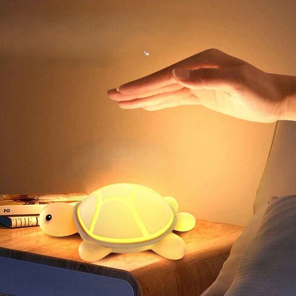 veilleuse poser sur la table de la chambre avec une main  qui va tapoter dessus pour changer ou eteindre la lumiere